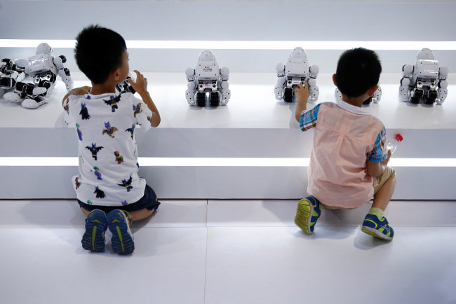 Children playing with robots at the 2017 World Robot Conference. [Photo: VCG]