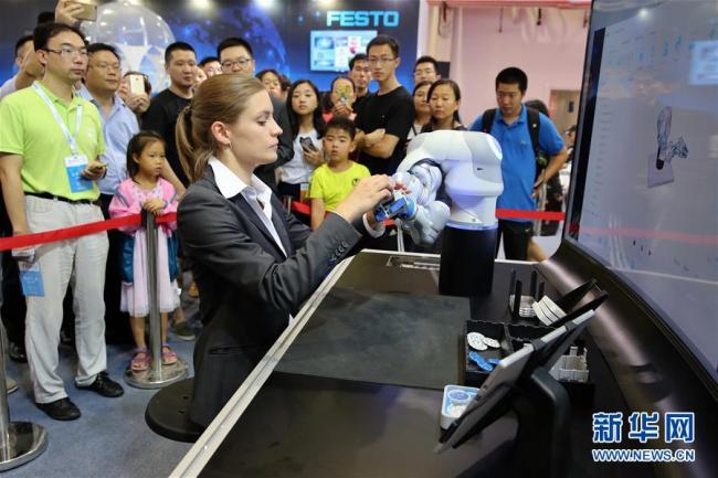 An engineer is testing a robot from her company. [Photo: from Xinhua] 