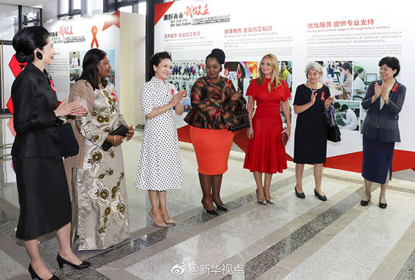 Peng Liyuan invites foreign guests to an advocacy activity on HIV/AIDS control in the southeastern city of Xiamen on Tuesday. [Photo: Xinhua]