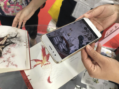 Holding a mobile phone in front of any drawing of the picture book "Strange Tales from Classic of Mountains and Seas", readers could watch how dynamic animation superimposes upon the portraits on paper. [Photo:China Plus]