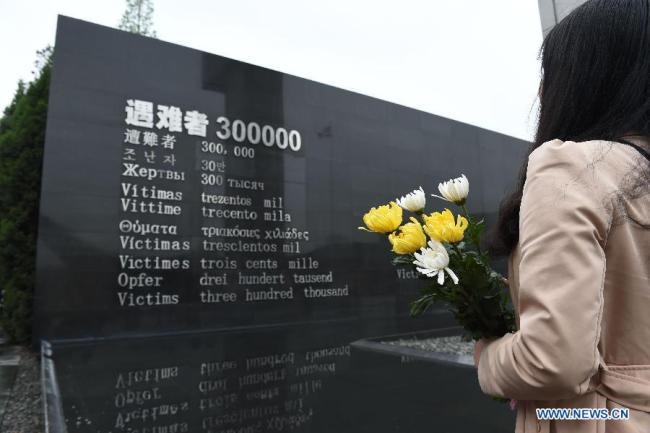 A resident mourn the Nanjing Massacre victims at the Memorial Hall of the Victims in Nanjing Massacre by Japanese Invaders on the Qingming Festival in Nanjing, capital of east China's Jiangsu Province, April 5, 2015. Japanese troops captured Nanjing, then China's capital, on Dec. 13 of 1937 and started a 40-odd-day slaughter. More than 300,000 Chinese soldiers who had laid down their arms and civilians were murdered, and over 20,000 women were raped. [File Photo: Xinhua/Sun Can]