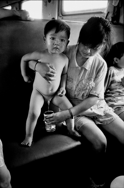 A small boy urinates into a can.[Photo:Courtesy of Wang Fuchun and provided by Hinabook]