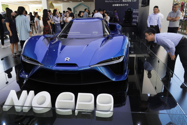 Visitor looking at the Nio EP9, an electric-powered two-seated supercar manufactured by NIO during a promotion event at a shopping mall in Beijing, Monday, Sept. 11, 2017. [Photo: AP/Andy Wong]