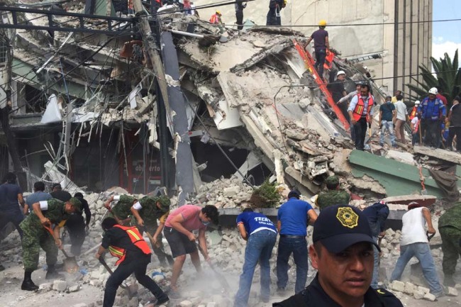 People search for survivors in a collapsed building in the Roma neighborhood of Mexico City, Tuesday, Sept. 19, 2017. A powerful earthquake has jolted Mexico, causing buildings to sway sickeningly in the capital on the anniversary of a 1985 quake that did major damage. [Photo: AP]