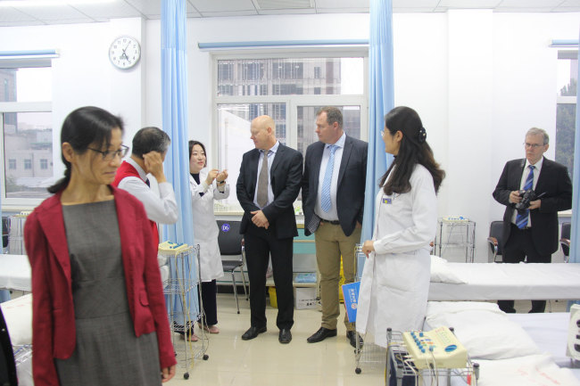 Ole Frydenlund, director of the TCM center in Tonsberg, and head of the St. Olav Eye Clinic and his partner Erik Vinje take a tour at the TCM treatment center at the Eye Hospital affiliated with the China Academy of Chinese Medical Sciences in Beijing on October 17, 2017. [Photo: China Plus]