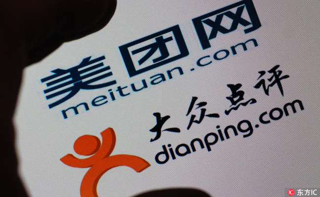A Chinese netizen looks at logos of online group buying site meituan.com, upper, and restaurant rating website Dianping.com on his computer in Tianjin, China, 8 October 2015. [Photo: IC]