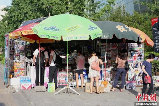 People shop at a newsstand in Beijing. [File photo: Chinanews.com]