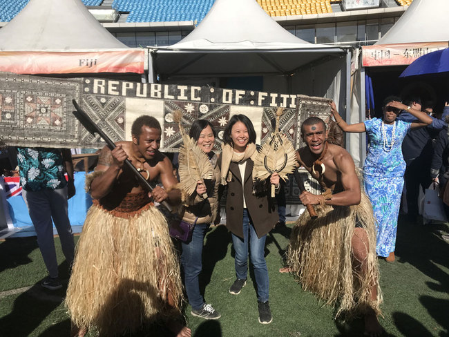 Performers from Fiji pose for photos with people at the "International Charity Sale for Healthy Villages in Yunnan," on October 29, 2017. [Photo: China Plus] 