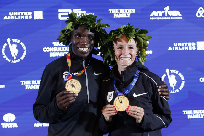 Men's race winner Geoffrey Kamworor, of Kenya, and women's race winner Shalane Flanagan, of the United States, pose together after the New York City Marathon, Sunday, Nov. 5, 2017, in New York. (AP Photo/Jason DeCrow)