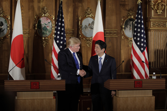 President Donald Trump, left, and Japanese Prime Minister Shinzo Abe shake hands during a joint news conference at the Akasaka Palace, Monday, Nov. 6, 2017, in Tokyo. [Photo:AP]