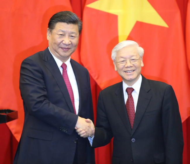 Chinese President Xi Jinping, also general secretary of the Communist Party of China, and Nguyen Phu Trong, general secretary of the Communist Party of Vietnam, witness the signing of a memorandum of understanding on joint implementation of the Belt and Road Initiative and Vietnam's "Two Corridors and One Economic Circle" plan, as well as a series of cooperation documents after their talks in Hanoi, Vietnam, on Nov. 12, 2017. [Photo: Xinhua/Yao Dawei]