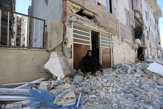 A man sits outside a damaged belonging following an earthquake in Sarpol-e Zahab county in Kermanshah, Iran November 13, 2017.[Photo: VCG]