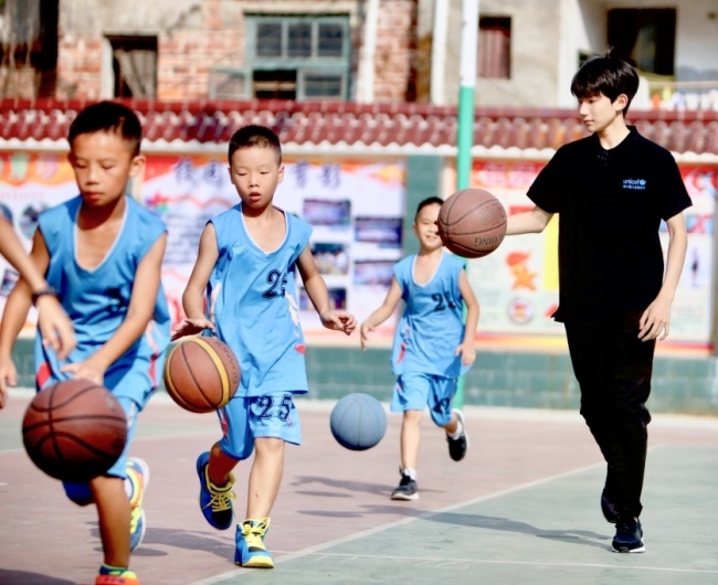Wang Yuan plays basketball with the students at a child-friendly school in Sanjiang. [Photo: courtesy of UNICEF/Xia Yong]