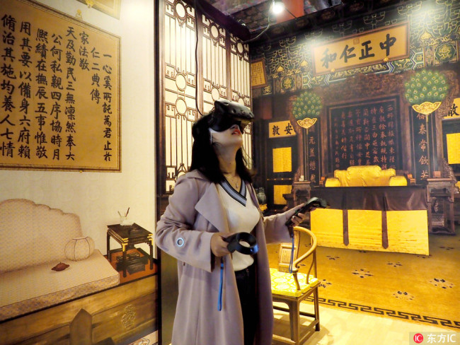 A visitor experiences VR technology during the exhibition "Discovering the Hall of Mental Cultivation: A Digital Experience" at the Palace Museum in Beijing, October 11, 2017. [Photo: IC]