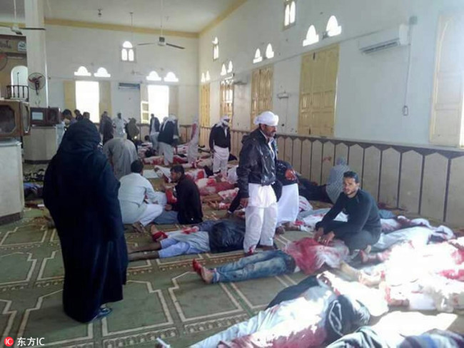 People sit next to bodies of worshippers killed in attack on mosque in the northern city of Arish, Sinai Peninsula, Egypt, 24 November 2017. [Photo: IC]
