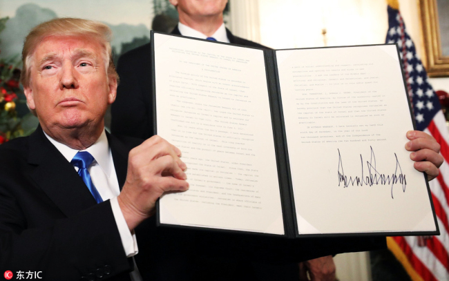 US President Donald Trump signs his proclamation about his controversial decision to formally recognize Jerusalem as the capital of Israel, and his plan to relocate the US embassy to that city, in the Diplomatic Room of the White House in Washington, December 6, 2017. [Photo: IC]