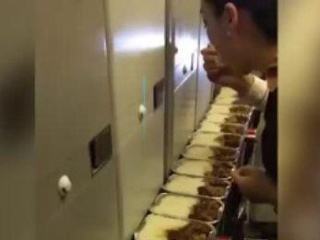 A stewardess tasting a row of airline meals in front of her. [Photo:The Beijing News]