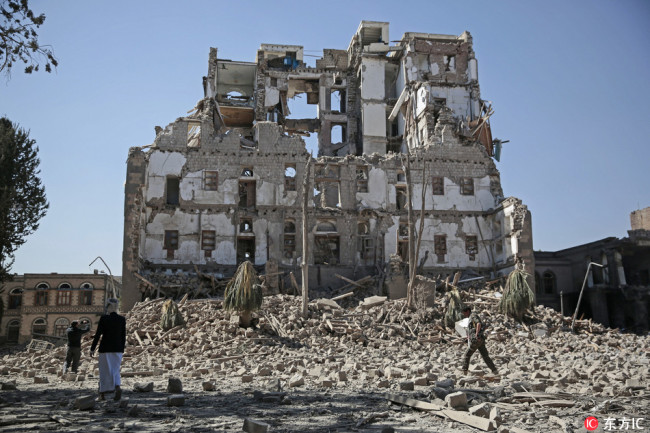 Houthi Shiite rebels walk amid the rubble of the Republican Palace that was destroyed by Saudi-led airstrikes, in Sanaa, Yemen, December 6, 2017. [Photo: IC]