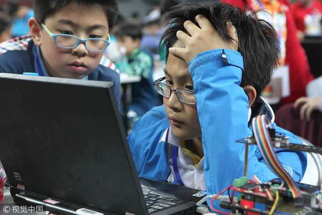 A primary school student codes computer programs for his robot during the 2015 Robo Cup in Shenzhen, Guangdong Province on April 24, 2015. [File Photo: VCG]