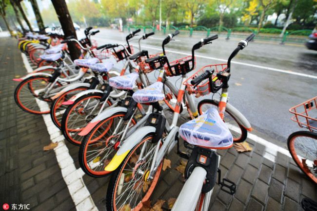 A row of Mobike's bicycles with white seat covers printed with advertising in Shanghai, on November 30, 2017. [Photo: IC]