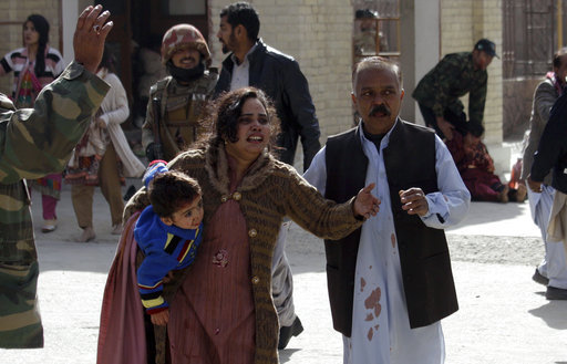 A man helps an injured woman and a child following an attack on a church in Quetta, Pakistan, Dec. 17, 2017. [Photo: AP]
