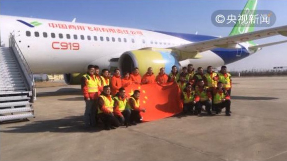 Crew members pose for a photo after China's second homemade COMAC C919 passenger jet accomplished its first trial flight. [Photo: CCTV]