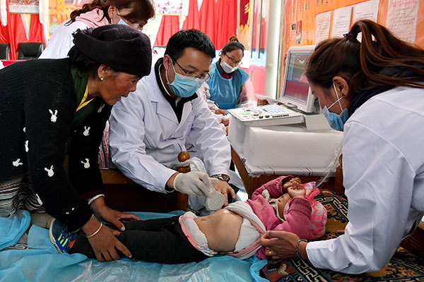 A doctor checks a 2-year-old child who was diagnosed with echinococcosis in Nakarze county in the Tibet autonomous region. [Photo: Xinhua]