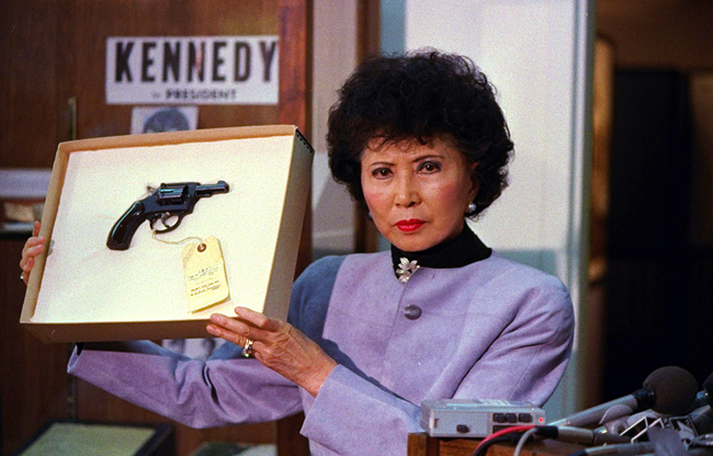 California Secretary of State March Fong Eu displays the gun used by Sirhan Sirhan to assassinate Robert Kennedy in Los Angeles, during a news conference in Sacramento on April 19, 1988. [File Photo: AP/Walt Zeboski]