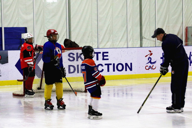 Russian hockey coach Dmitrii with teenagers playing ice hockey at the Citizen Ice and Snow Sports Center in Beijing, December 24, 2017 [Photo: China Plus/Sang Yarong]