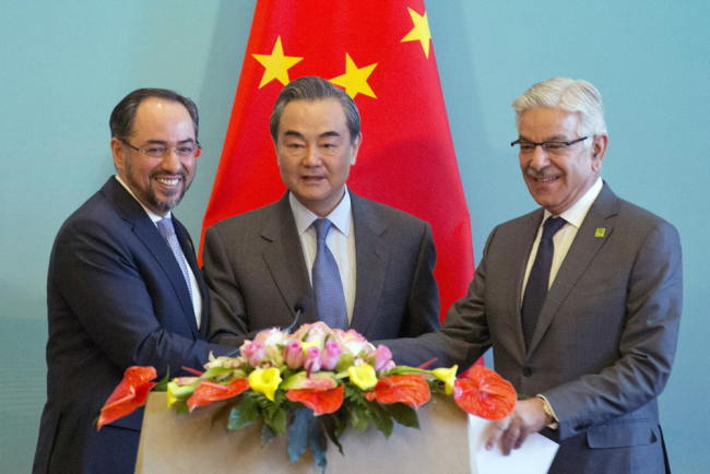 From left, Afghanistan Foreign Minister Salahuddin Rabbani, Chinese Foreign Minister Wang Yi and Pakistani Foreign Minister Khawaja Asif hold hands to pose for a photo after a press conference for the 1st China-Afghanistan-Pakistan Foreign Ministers' Dialogue held in Beijing, China, December 26, 2017. [Photo: AP/Ng Han Guan]