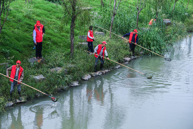 Workers clean a river in Changxing county, Zhejiang province, in October. The county has invested 7.5 billion yuan ($1.15 billion) in improving its waterways and the aquatic environment over the past three years. [Photo: Xinhua]
