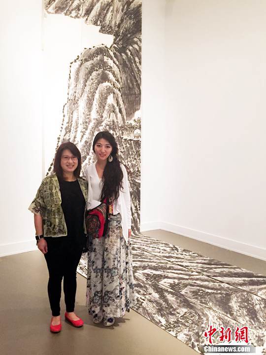 Artist Tian Haisu (right) and Anita Lee, wife of then San Francisco mayor Edwin Lee, stand in front of Tian’s artwork. The artwork was featured at an exhibition in San Francisco on June 14, 2015. [File Photo: Chinanews.com]