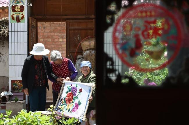 Bu Xilan (R) introduces embroidery skill to neighbours in Maping Village of Longde County, northwest China's Ningxia Hui Autonomous Region, May 23, 2017. Rural embroidery in Longde has a history of more than 100 years. The 67-year-old Bu was awarded as a successor of intangible cultural heritage of Ningxia in 2003. She also taught the skill to her children and neighbours.[Photo: Xinhua]
