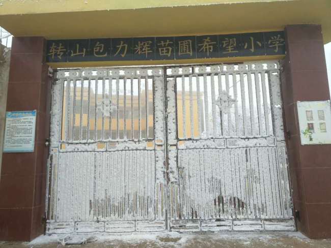 The gate of Zhuan Shan Bao Primary School of Xinjie County is covered in ice. [Photo provided to chinadaily.com.cn]