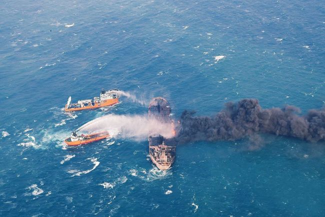 Photo from January 11, 2018 shows the "Shen Qian Hao" (top L) spraying foam on burning oil tanker "Sanchi" (R) at sea off the coast of eastern China. [File photo: VCG] 