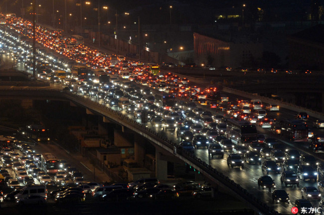 Night view of highways and roads overcrowded by masses of vehicles during a traffic jam at CBD (Central Business District) on World Car-Free Day in Beijing, China, 22 September 2014. [File photo: IC]