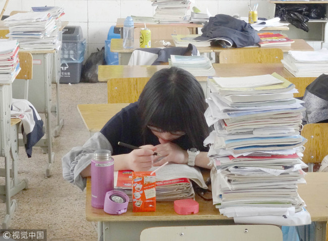 A high school student is doing homework in the classroom during a holiday. [Photo: VCG]