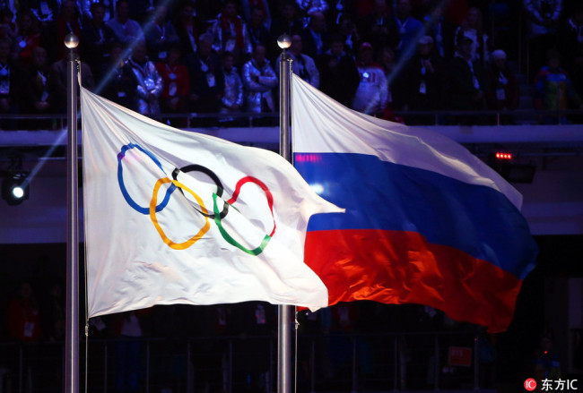 The Olympic flag (L) and the Russian flag (R) during the Closing Ceremony of the Sochi 2014 Olympic Games in the Fisht Olympic Stadium in Sochi, Russia, February 23, 2014.[File Photo: IC] 