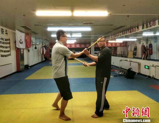 Photo shows Rhio, a veteran Arnis practitioner, teaching a student Arnis skills at a gym in Beijing. [Photo: Chinanews.com]
