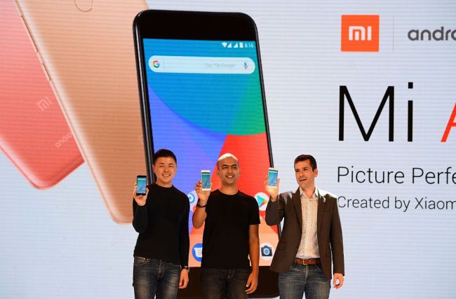 (L-R) Donovan Sung, director of product management and marketing at Xiaomi Global, Manu Jain, managing director of Xiaomi India, and global director of Android Partner Programs Jon Gold hold the newly launched Xiaomi Mi A1 smartphone at a function in New Delhi on September 5, 2017. [Photo: VCG]
