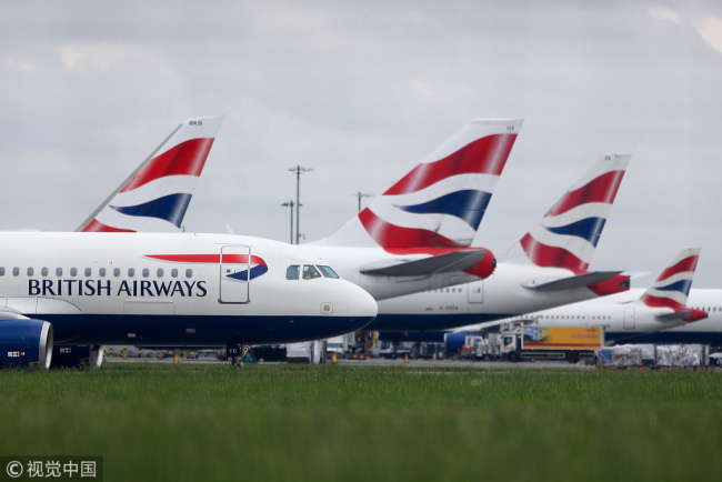 A passenger aircraft, operated by British Airways, a unit of International Consolidated Airlines Group SA (IAG), passes other British Airways passenger aircraft on the tarmac at London Heathrow Airport, in London, U.K., on Tuesday, May 30, 2017. [Photo: VCG]