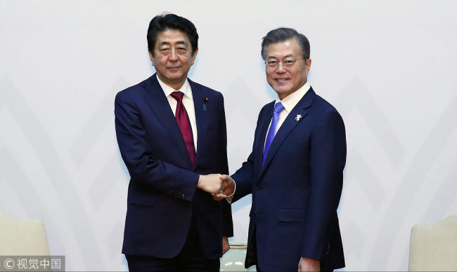 South Korean President Moon Jae-in (R) shakes hands with Japanese Prime Minister Shinzo Abe (L) during their meeting in PyeongChang, South Korea, February 9, 2018. [Photo: VCG]