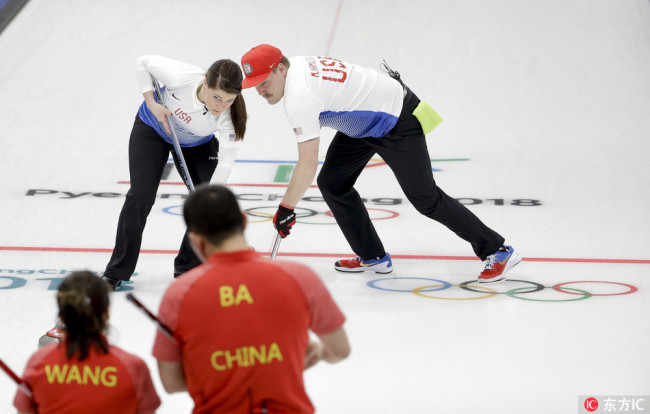 United States' siblings Matt, right, and Becca Hamilton sweep the ice during a mixed doubles curling match against China's Wang Rui and Ba Dexin at the 2018 Winter Olympics in Gangneung, South Korea, Saturday, Feb. 10, 2018. [Photo: Natacha Pisarenko/IC]
