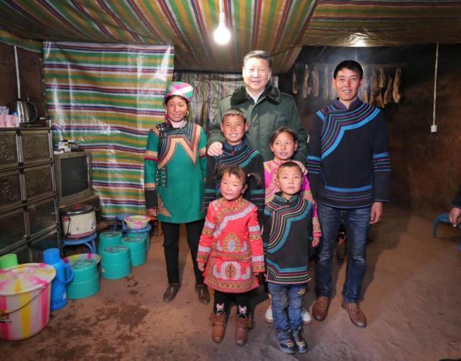 Xi Jinping, general secretary of the Communist Party of China Central Committee, poses for photo with a family of Yi ethnic group in Zhaojue county, southwest China's Sichuan Province on Sunday. [Photo: Xinhua]