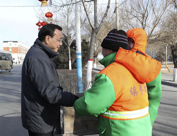 Chinese Premier Li Keqiang (L) shakes hands with sanitation workers in Zhenlai County in the city of Baicheng, northeast China's Jilin Province, Feb. 12, 2018. [Photo: Xinhua/Pang Xinglei]