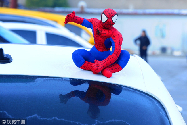 A Spiderman decorative toy is placed on the roof of a car. [File photo: VCG]
