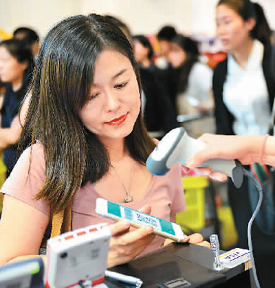 A customer uses Alipay at the check-out of a shopping mall in Singapore on December 11, 2016. Alipay is a world-leading mobile payment platform established by China's Internet giant Alibaba. [File Photo: Xinhua]