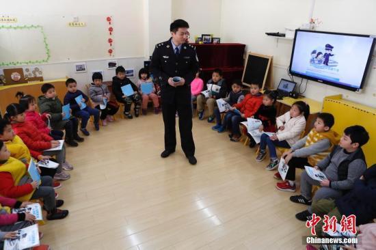 A police officer introduces safety knowledge to the students in a kindergarten in Beijing. [File photo: Chinanews.com]