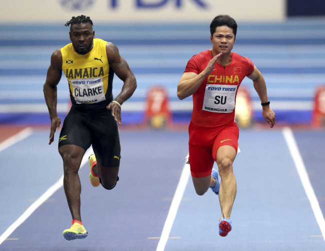 Jamaica's Everton Clarke, left and China's Su Bingtian. right, compete during a men's 60 meters heat at the World Athletics Indoor Championships in Birmingham, Britain, Saturday, March 3, 2018. [Photo AP/Alastair Grant]