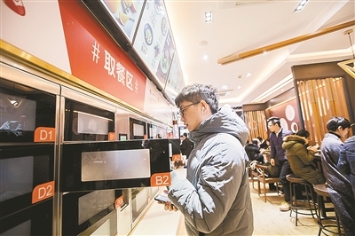 A customer takes his meal from cupboards at an unmanned restaurant of Wufangzhai in Hangzhou, capital city of east China's Zhejiang Province. [Photo: hangzhou.gov.cn]